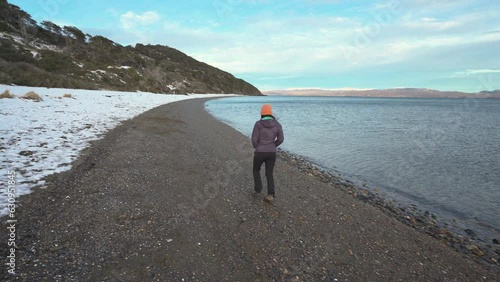 Woman walking on a snowy beach in Patagonia photo