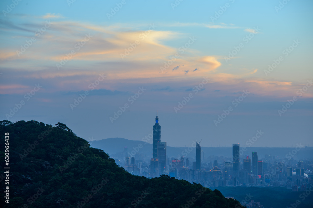 Blue sky with white dynamic clouds over the city at dusk at sunset. View of the urban landscape from Dajianshan Mountain, New Taipei City, Taiwan