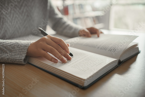 Student preparing for college test, exam, reading book, studying textbook, writing notes, making summary for class report. Learning workplace table, hands with pencil close up