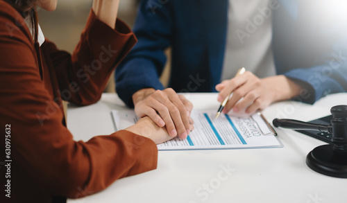 Business people compassionately holding hands and discussing contract papers with laptop and tabletat office room.