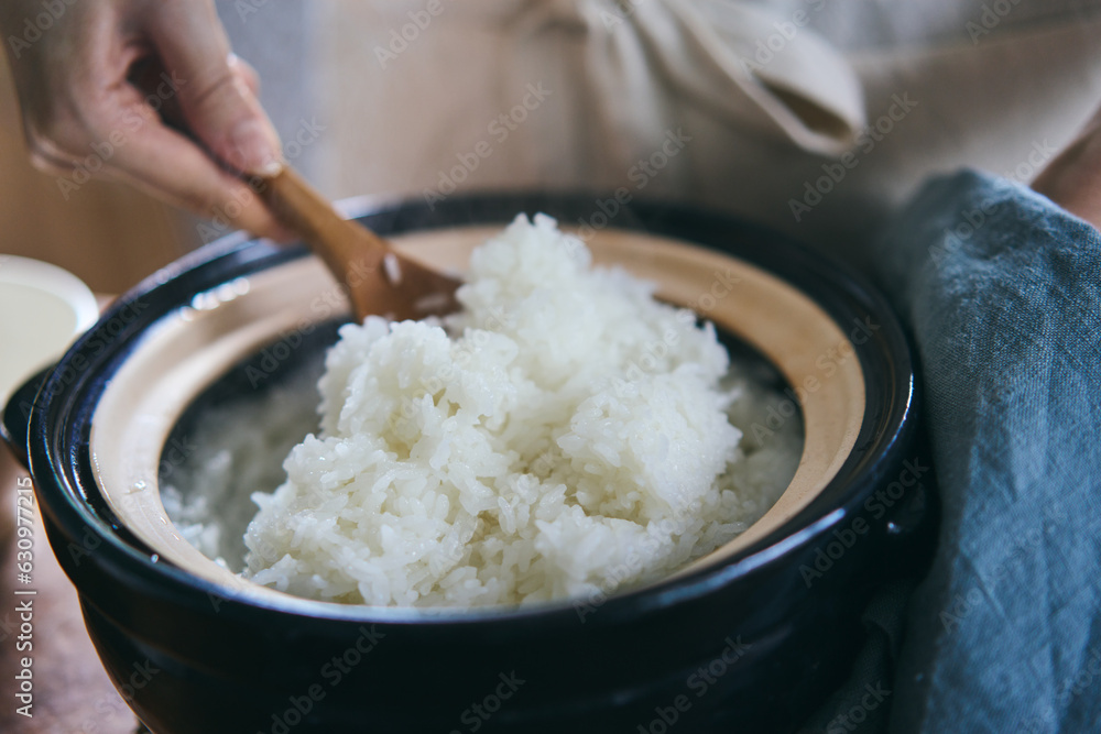 土鍋で炊いたご飯をしゃもじで混ぜる 土鍋で炊いたご飯をしゃもじで混ぜる