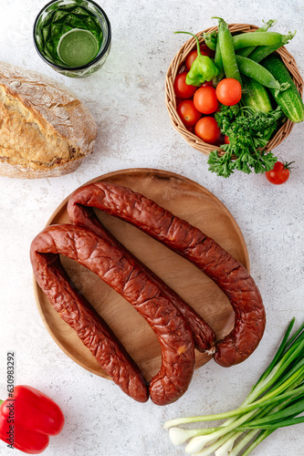 Closeup view of smoked beef sausage rings on wooden cutting boar
