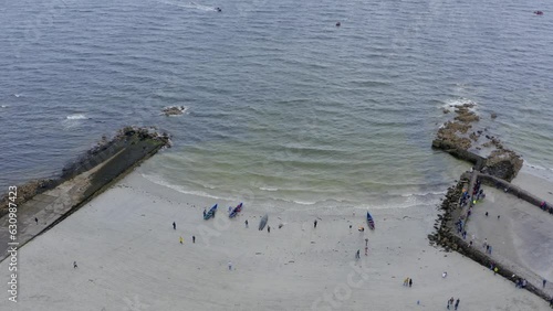 Aerial pullback reveals Currach boats on ladies beach by diamond tide pools photo