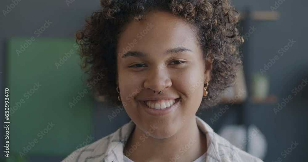 Close-up portrait of cheerful young African American lady smiling expressing happiness at home. People and positive emotion concept. Close-up portrait of cheerful young African American lady smiling expressing happiness at home. People and positive emotion concept.