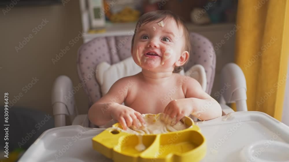 baby eats dirty. happy family a lifestyle kid toddler concept. baby girl dirty sitting messing with food at the table for feeding in the kitchen. grimy toddler in the kitchen baby eats dirty. happy family a lifestyle kid toddler concept. baby girl dirty sitting messing with food at the table for feeding in the kitchen. grimy toddler in the kitchen