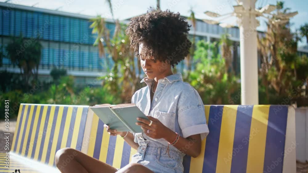 Teen girl studying textbook sitting campus bench close up. Student reading book. Teen girl studying textbook sitting campus bench close up. Student reading book.