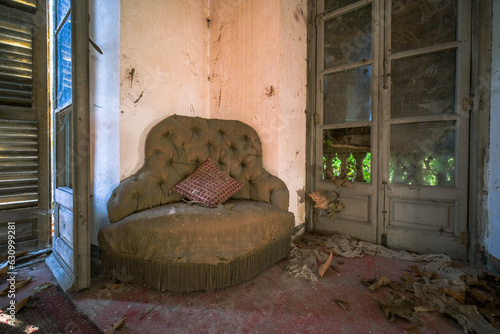 an old armchair, with cushion in an abandoned villa with broken glass photo