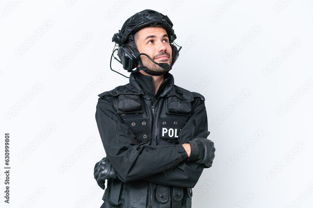 Young caucasian SWAT man isolated on white background looking up while smiling Young caucasian SWAT man isolated on white background looking up while smiling