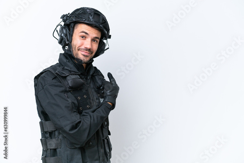 Young caucasian SWAT man isolated on white background pointing back © luismolinero
