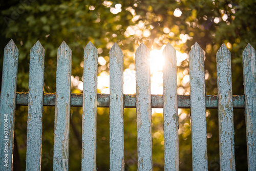 beautiful wooden fence in the village in the contrast sunlight