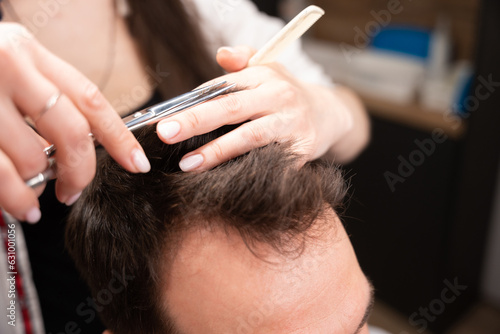 Adult male sits in a barbers chair