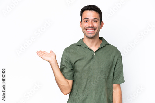Young handsome man over isolated white background holding copyspace imaginary on the palm to insert an ad