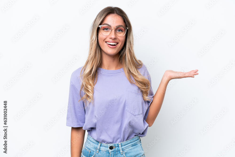 Young Uruguayan woman isolated on white background holding copyspace imaginary on the palm to insert an ad Young Uruguayan woman isolated on white background holding copyspace imaginary on the palm to insert an ad