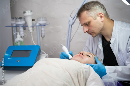 girl at a cosmetologist man during treatment procedures