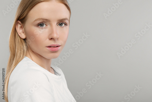 Portrait of beautiful young woman on grey background. Space for text