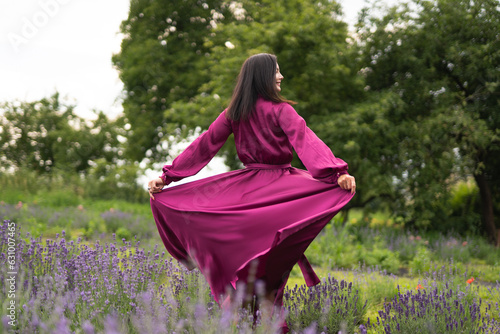 A girl in a burgundy dress on a field of lavender flowers