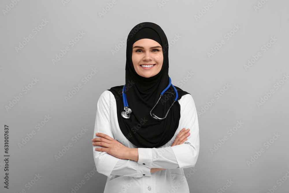 Muslim woman wearing hijab, medical uniform with stethoscope on light gray background Muslim woman wearing hijab, medical uniform with stethoscope on light gray background