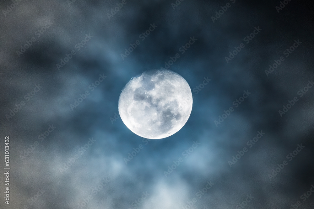 Waning gibbous moon at 92 percent illuminated with clouds drifting past in the dark night sky