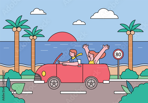 car driving holiday trip.  A couple enjoys driving down a beach road in a convertible.