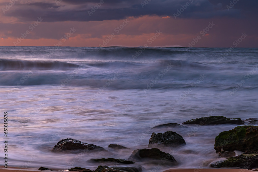 Obraz premium Sunrise seascape with low clouds and waves