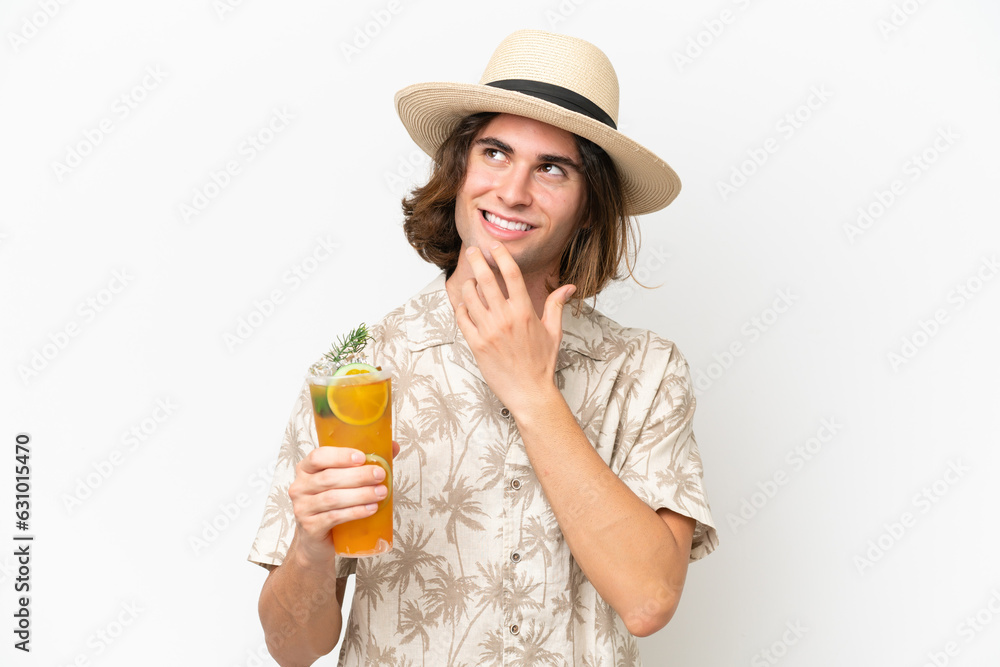 Young handsome man holding a cocktail isolated on white background looking up while smiling Young handsome man holding a cocktail isolated on white background looking up while smiling