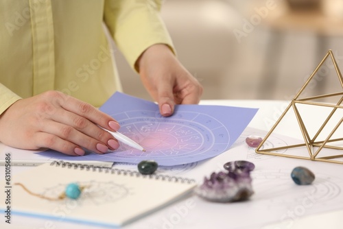 Fotografie Astrologer using zodiac wheel for fate forecast at table, closeup