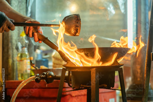 fried noodles cook in pan with big fire flame is hong kong style. Pad Thai favorite and famous Asian Thai street fast food in hot pan, Pad Thai is fried rice noodle dish a street food Thailand