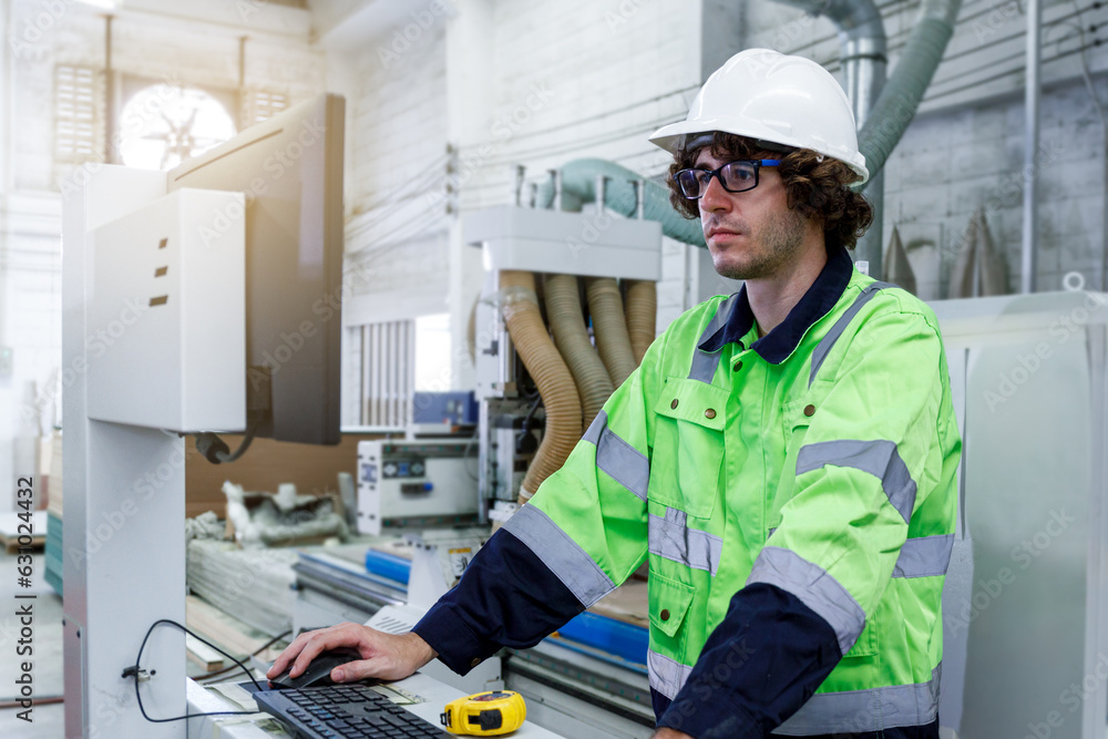 Portrait of a male engineer operating a computer, designing and controlling a machine. in the furniture industry Portrait of a male engineer operating a computer, designing and controlling a machine. in the furniture industry