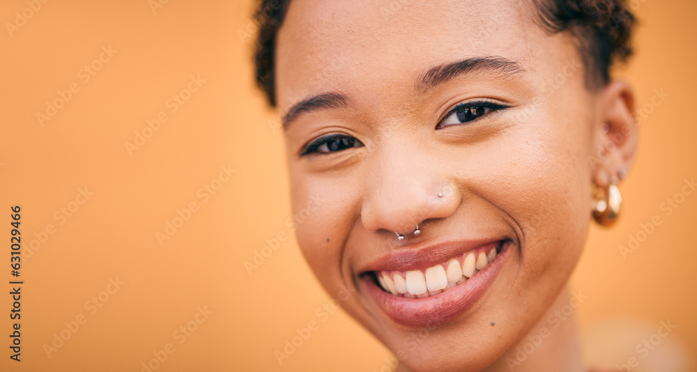 Obraz premium Happy, woman and face closeup in studio with smile and confidence feeling cute. Orange background, young portrait and African female person with trendy, piercing and student fashion with gen z glow