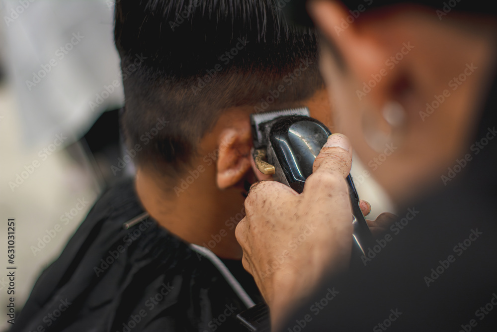 Fototapeta premium Close-up professional hairdresser using scissors and clippers and accessories for beautiful and decorating men hair Cutting hair for male customer, barbershop fashion and beauty hipster style concept