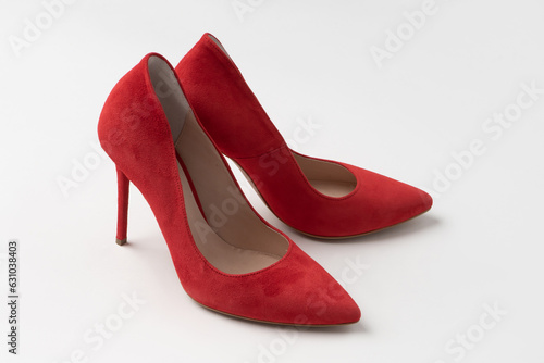 Elegant women's summer suede red stilettos. A new pair of shoes on a white background.