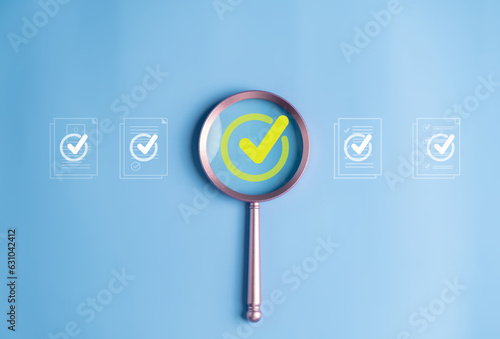 Magnifier enlarging the correct or check mark on blue background.e.
