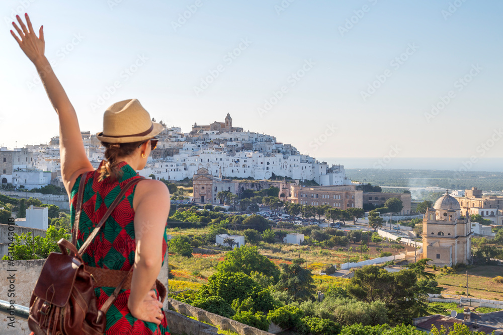 Young elegant  tourist with hat looking at Ostuni, the white city  in the south of italy