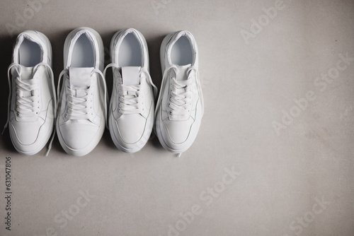 Close up details of white sneakers on the floor. Casual fashion style minimalistic shoes.