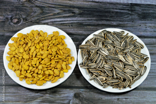 A snack of seeds of the sunflower (Helianthus annuus), Types are linoleic, high oleic and sunflower oil seeds, roasted unpeeled salty Citrullus lanatus watermelon seeds grains, selective focus photo