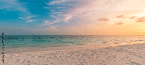 Beach sunset. Beautiful panoramic landscape, colorful golden sunset sky clouds. Closeup calm sea with waves splashing softly on sandy beach. Amazing sunrise landscape, summer nature, peaceful coast photo