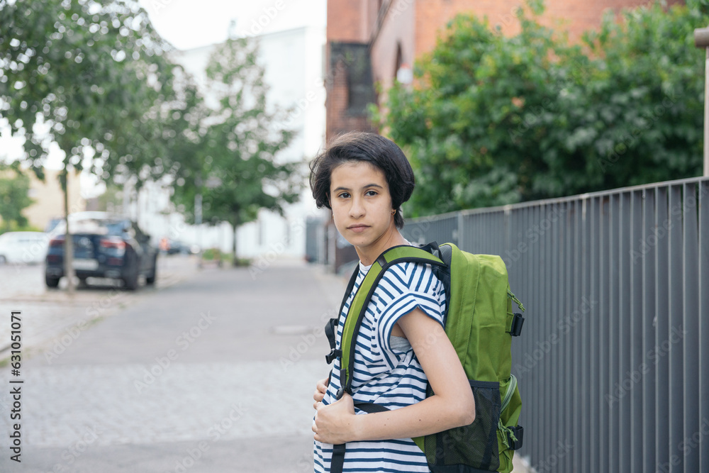 Young adolescent school girl with green backpack and looking at camera Young adolescent school girl with green backpack and looking at camera