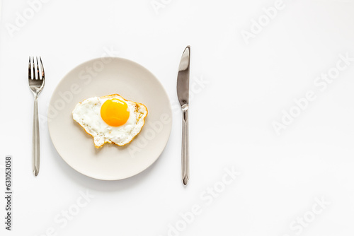 Fried egg on white plate, top view. Food background