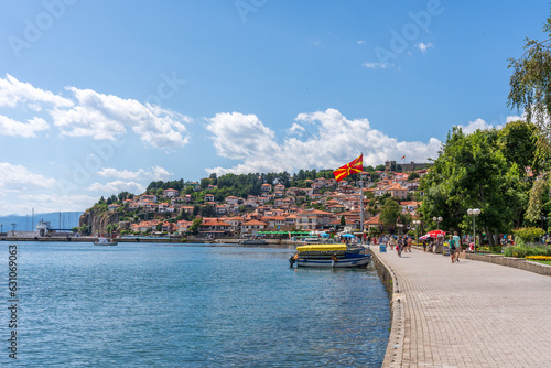 Walkway along Lake Ohrid with a city in the background and the Macedonian flag