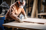 Carpenter wearing gloves cutting mdf board inside workshop