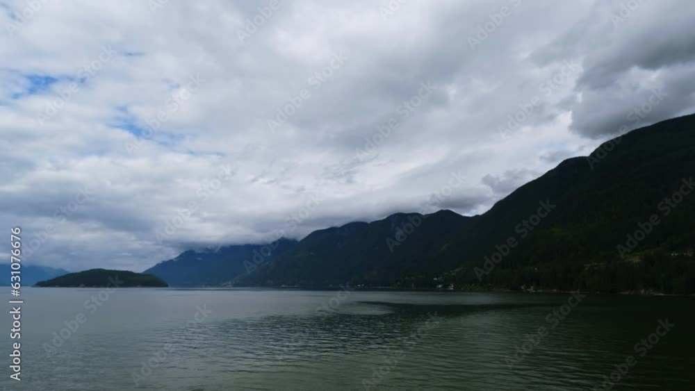Calm Waters With Cloudy Sky Scenery Along Vancouver Island Mountain Shoreline In Canada. Calm Waters With Cloudy Sky Scenery Along Vancouver Island Mountain Shoreline In Canada.