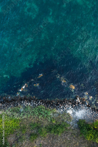 Aerial view to a rocky beach at sunset	 photo