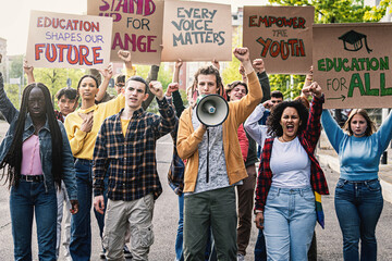 Multiracial Students Protesting for Education - Diverse group of young students marching, raising clenched fists and holding signs advocating for change in education.