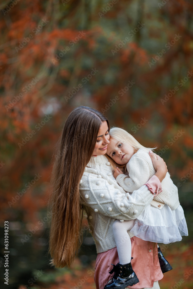 Beautiful young dark haired mother plays with her little daughter 3 years old in the autumn park. Walk. Family. Autumn. Beautiful young dark haired mother plays with her little daughter 3 years old in the autumn park. Walk. Family. Autumn.