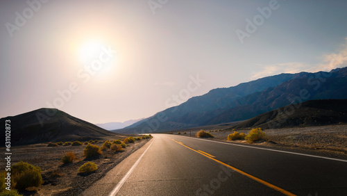 Sunrise on the road in Death Valley National Park in California. Hot dry desert climate in summer.