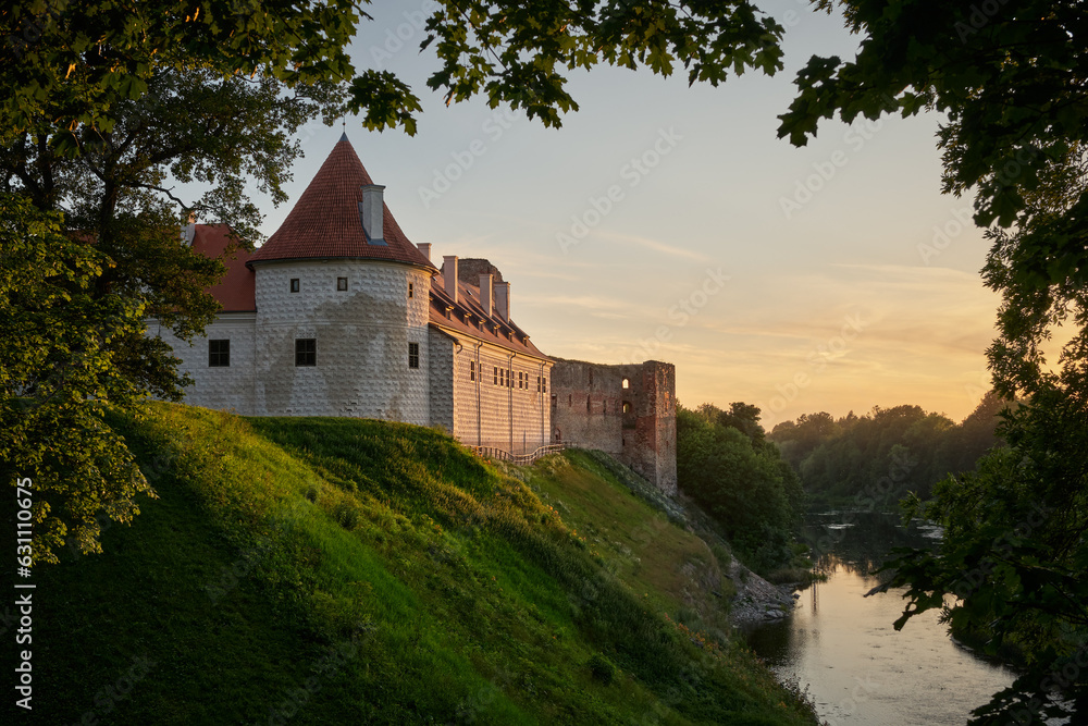 View of latvian tourist landmark attraction - ruins of medieval Bauska castle and the remains of a later palace at sunset. Bauska city, Latvia.