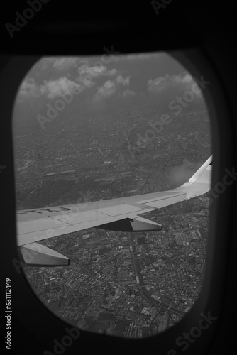 Black and white photo of a plane above the cloud