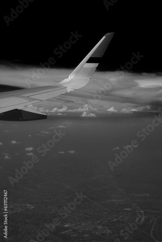 Black and white photo of a plane above the cloud