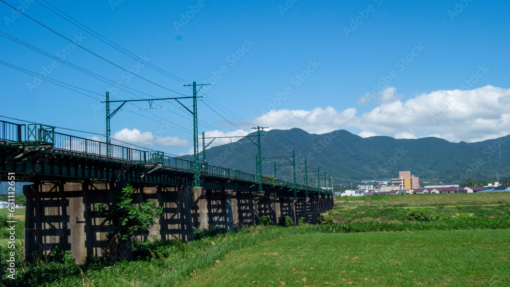 遠賀川に架かる鉄橋と福智山系の真夏の風景