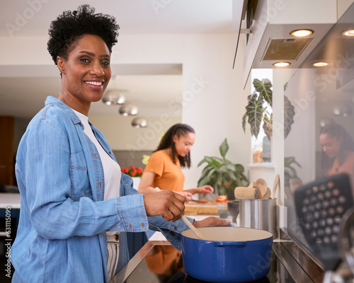 Portrait Of Mother With Teenage Daughter Helping To Prepare Meal At Home In Kitchen Together © Monkey Business